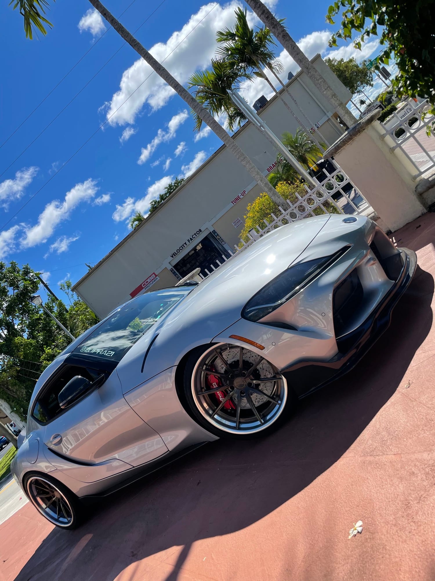 Slammed silver Toyota GR Supra MK5 on three-piece wheels outside the Velocity Factor shop