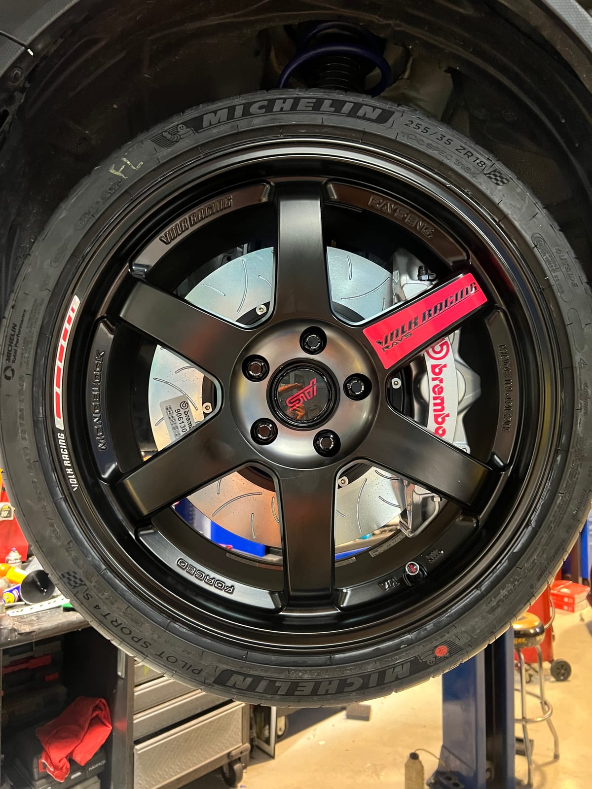 Red Brembo brake caliper behind a black RAYS Volk TE37 wheel at Velocity Factor