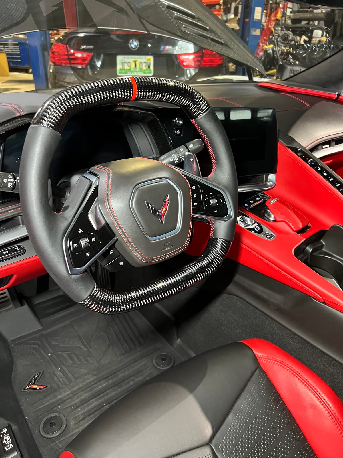 Chevrolet Corvette C8 carbon-fiber steering wheel with red centering stripe and red leather interior at Velocity Factor