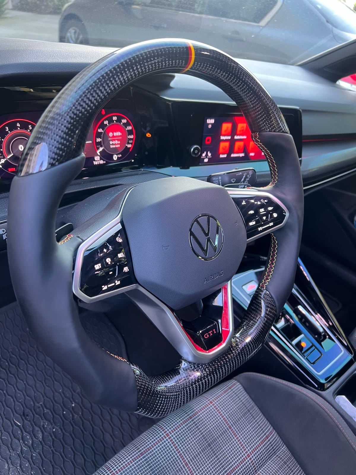 Volkswagen Golf GTI Mk8 carbon-fiber steering wheel with German-flag centering stripe installed at Velocity Factor