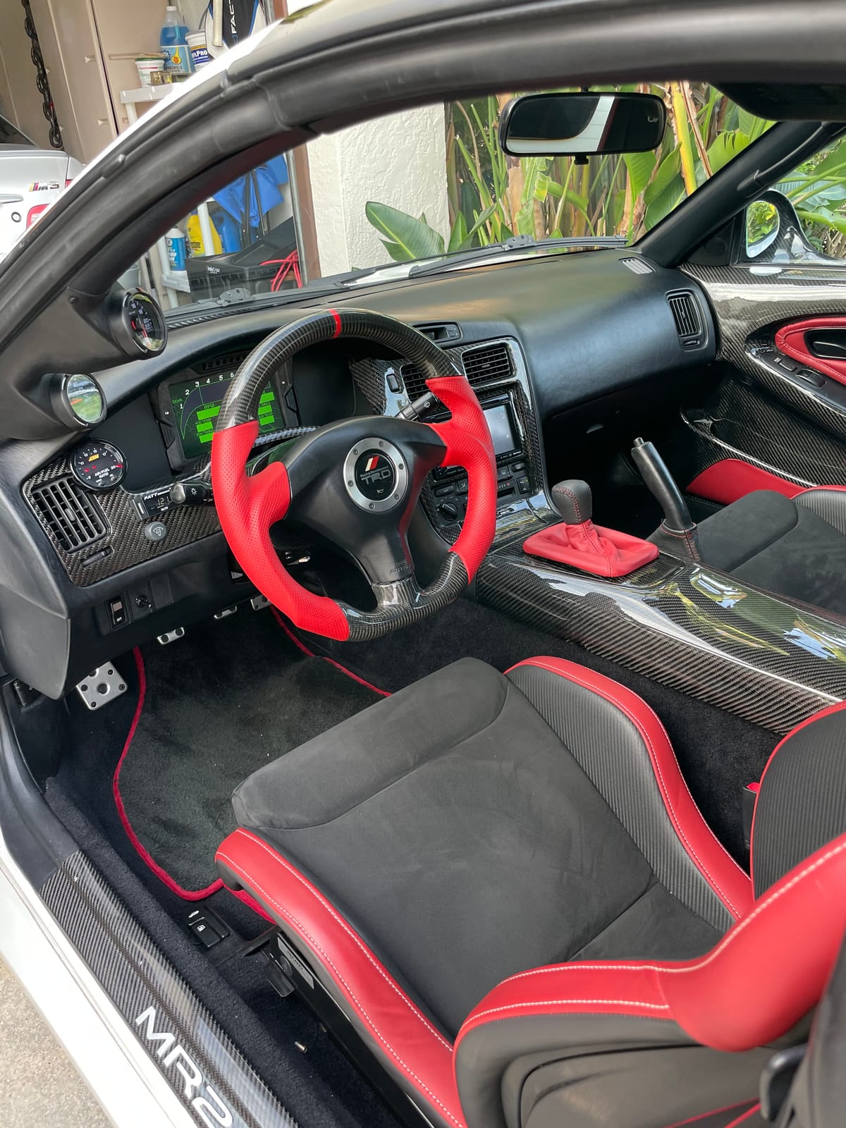 Fully customized Toyota MR2 interior with red and carbon-fiber TRD steering wheel and matching seats at Velocity Factor