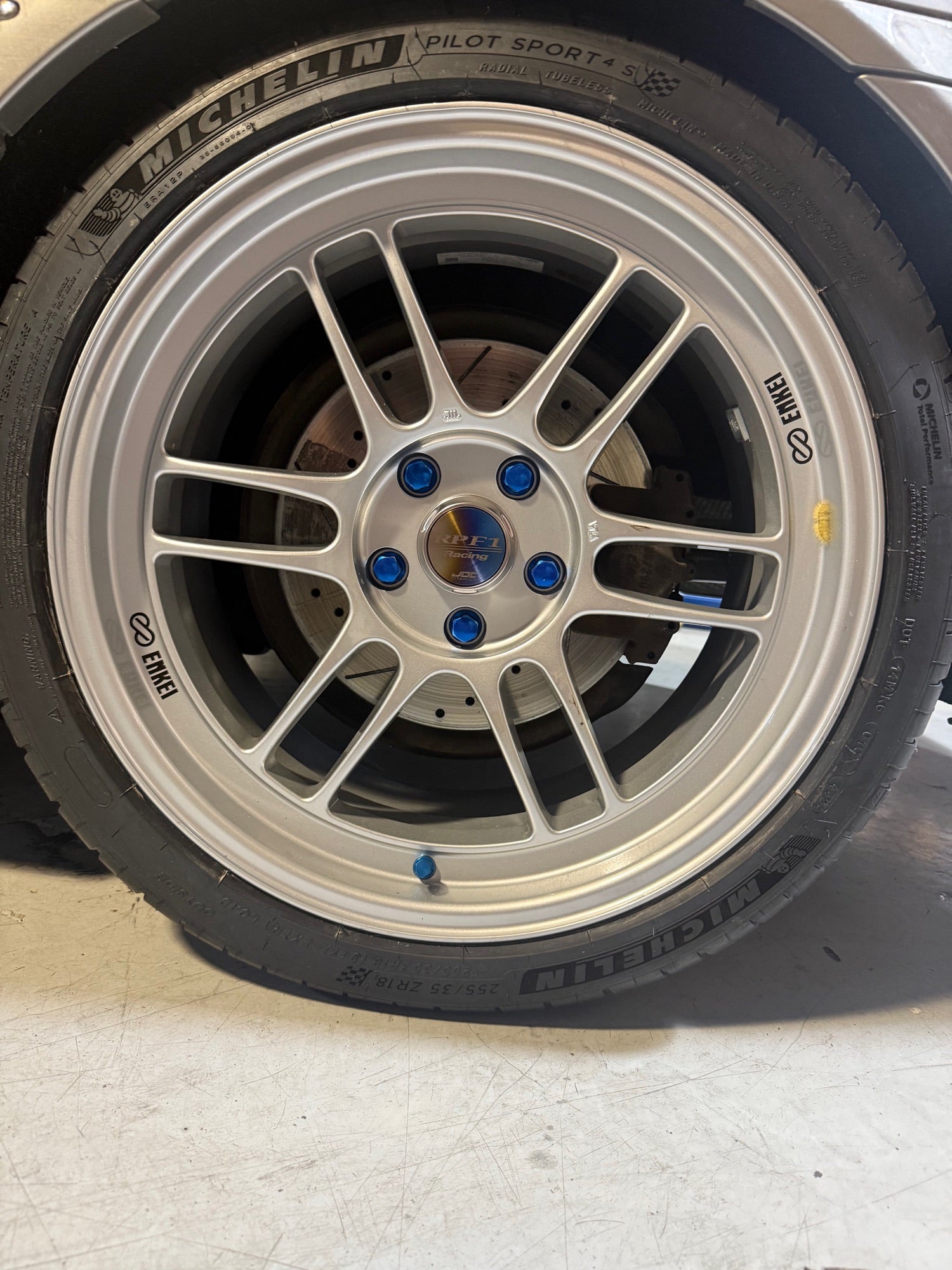 Silver Enkei RPF1 with blue titanium lug nuts and Michelin Pilot Sport 4S installed at Velocity Factor