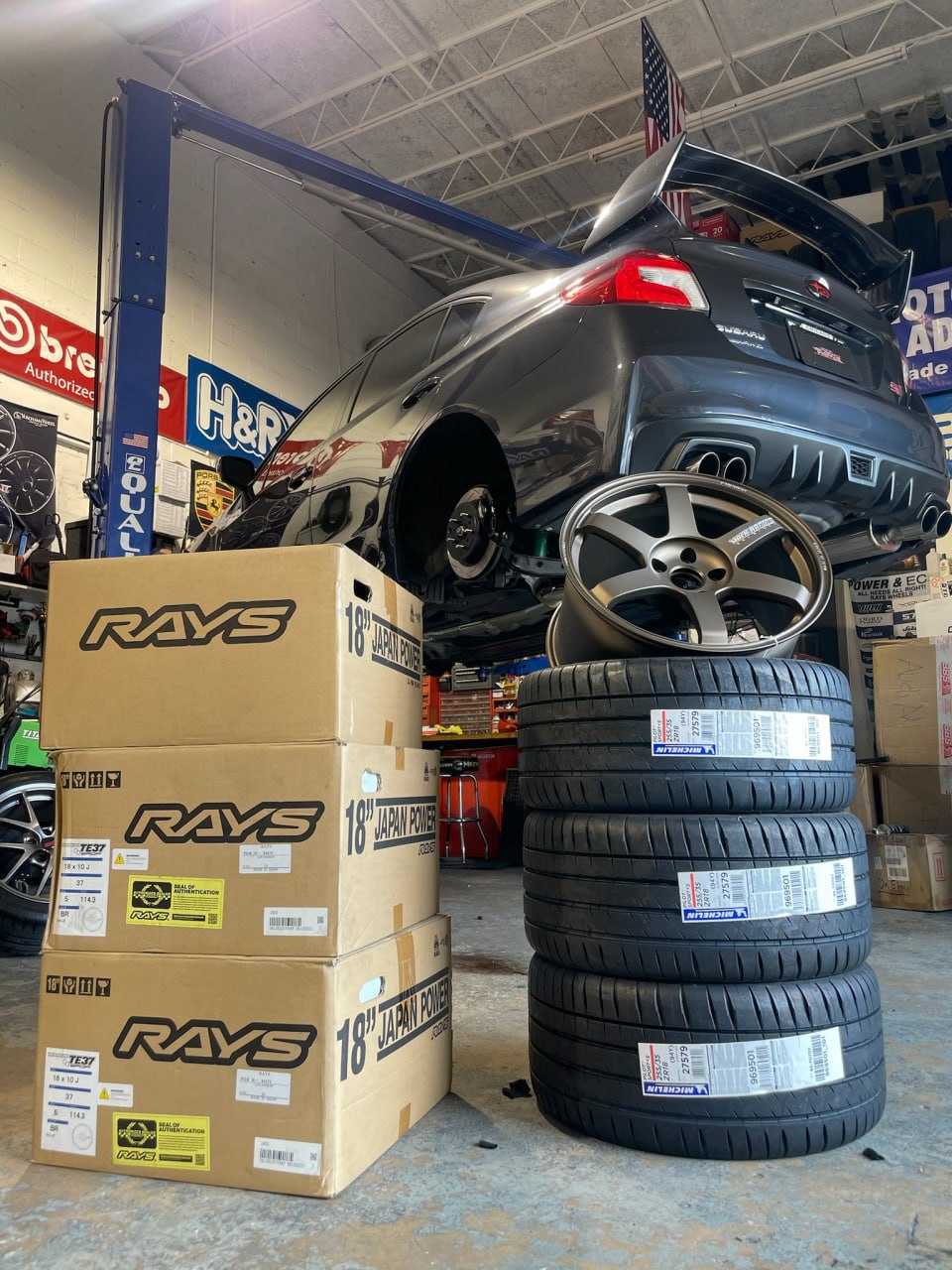 Subaru WRX STI in the Velocity Factor shop during a RAYS wheel and Michelin tire installation