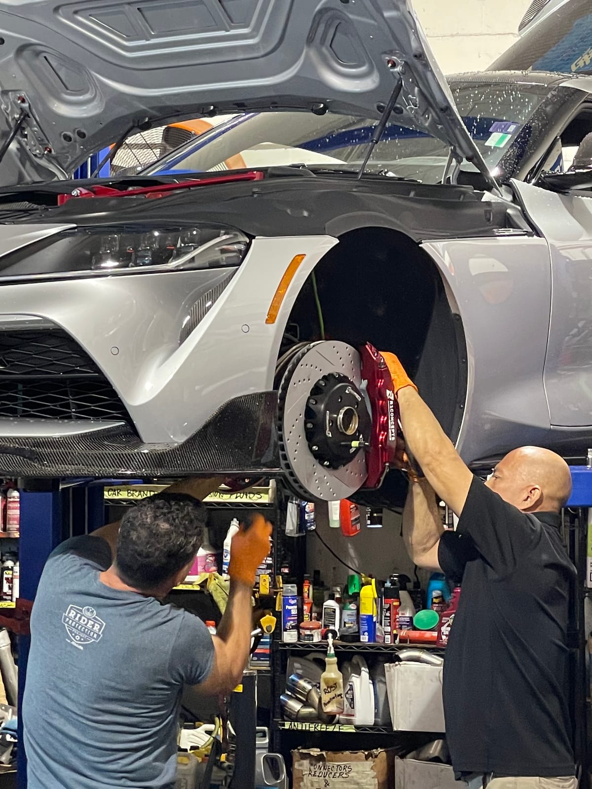 Velocity Factor technicians installing a big brake kit on a Toyota GR Supra on a lift
