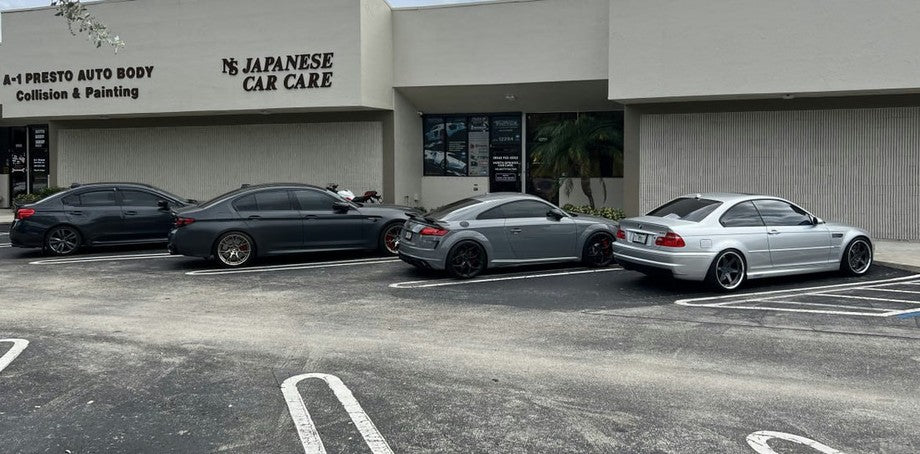BMW M5, Audi TT RS, and BMW E46 M3 parked in front of the Velocity Factor shop entrance on Wiles Road in Coral Springs