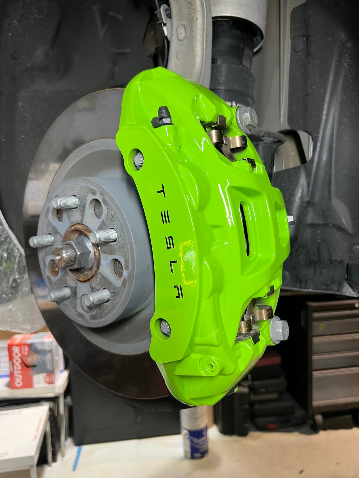 Tesla brake caliper refinished in bright green at Velocity Factor in Coral Springs