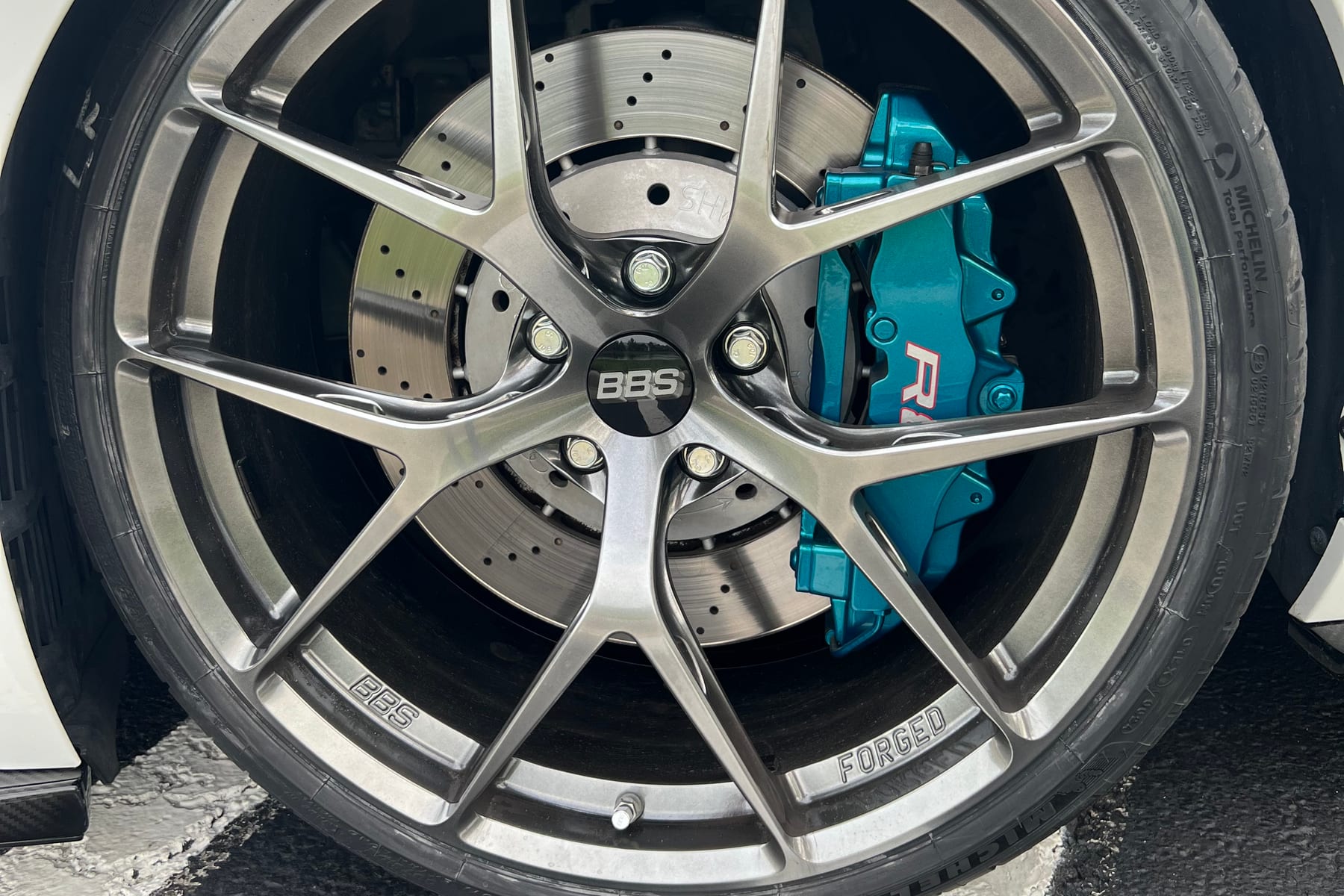 Teal refinished Audi R8 brake caliper behind a BBS forged wheel at Velocity Factor