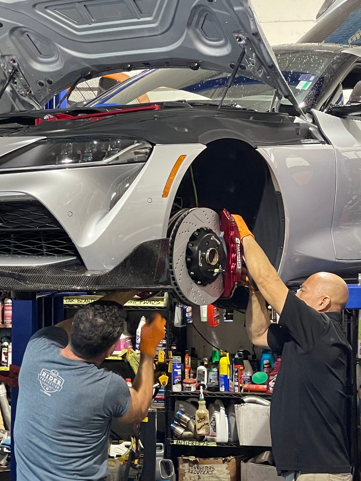 Velocity Factor technicians installing a red big brake kit on a Toyota GR Supra