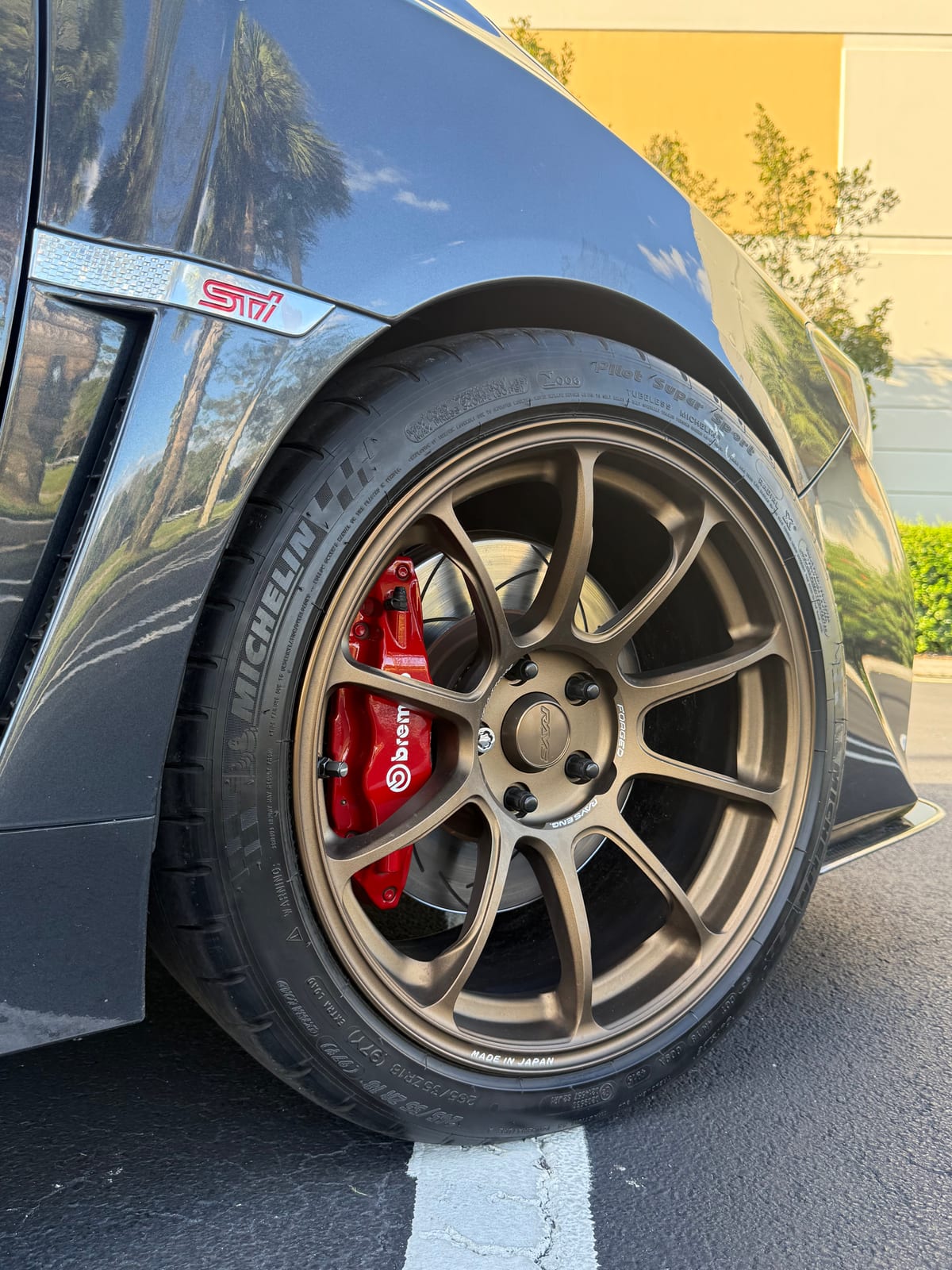 Red Brembo brake caliper behind a bronze wheel on a Subaru STI at Velocity Factor