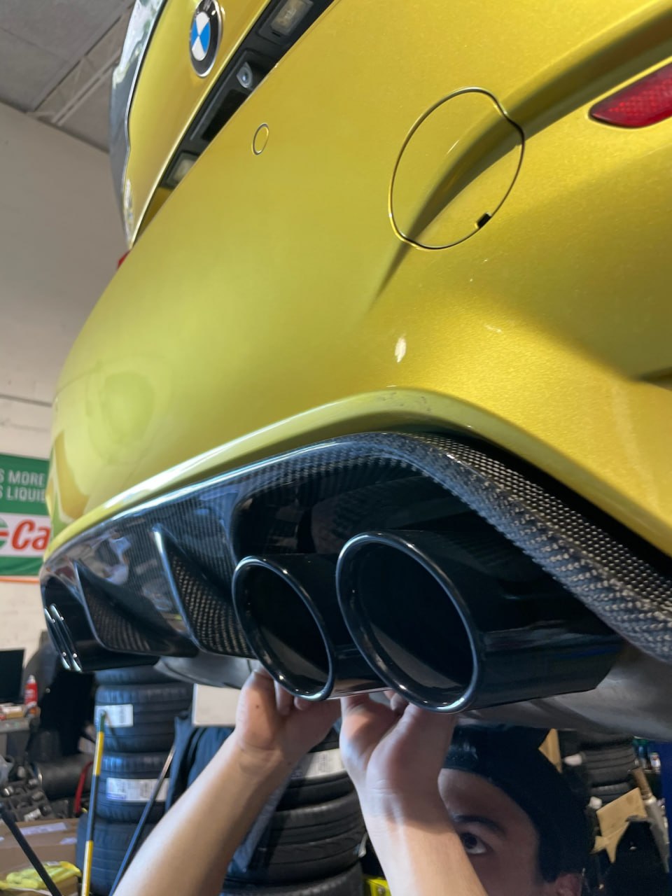 Carbon fiber rear diffuser and quad exhaust tips installed on an Austin Yellow BMW M at Velocity Factor