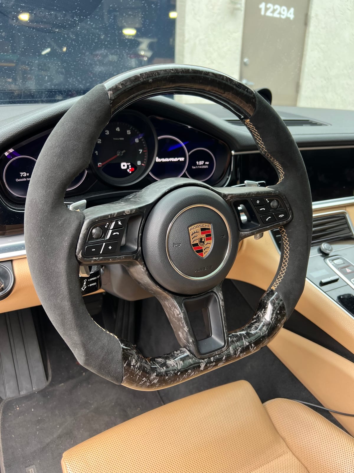 Porsche Panamera steering wheel upgraded with forged carbon and Alcantara grips with gold cross-stitching at Velocity Factor